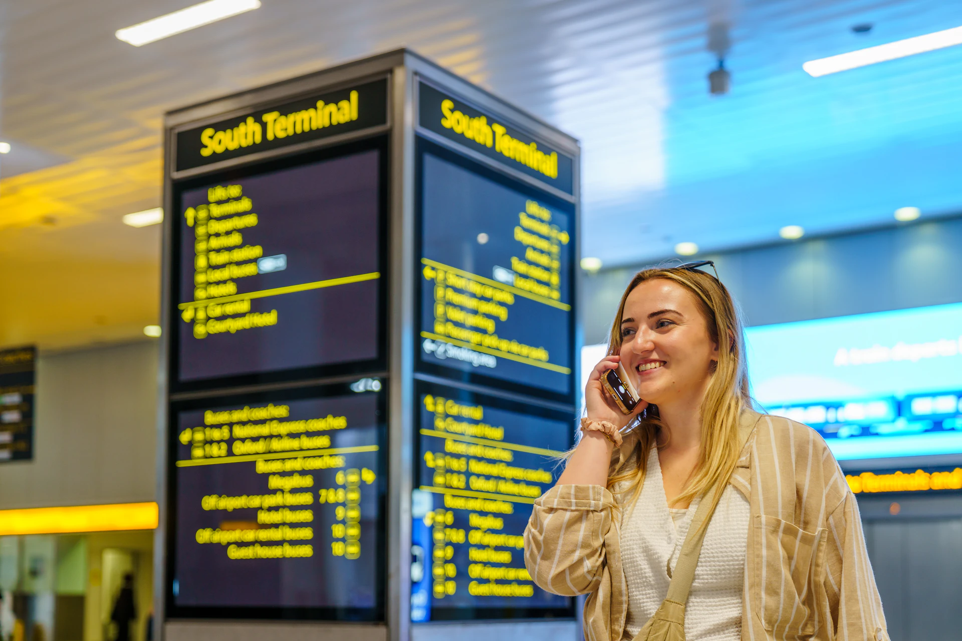 Traveller with phone in hand entering booking details at an airport
